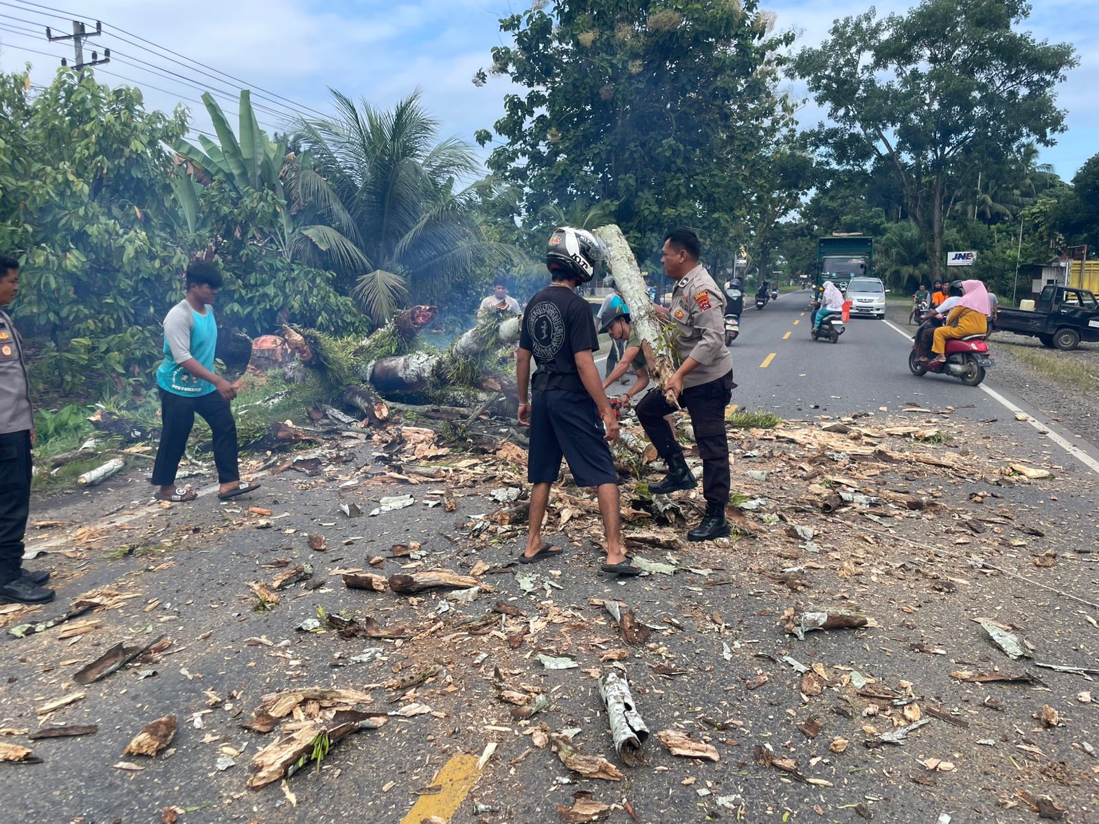 Cepat Tanggap, Polres Dharmasraya Bantu Warga Bersihkan Sisa Penebangan Pohon Mati di Jalan Lintas Sumatera